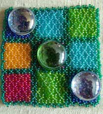 Lynn Davy beading, Noughts and Crosses set.  Symmetrical netting board with glass playing pieces.