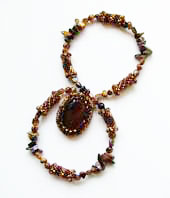 Lynn Davy Beading - Beading Gallery - Photography by Joanna Bury. Tigereye pendant  A gorgeous chunky tigereye cabochon captured in seed beads and hung from a necklace of beaded beads and tigereye chips; a proposed new kit design for Westcoast Jewellery   click on thumbnail to see larger image