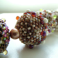Lynn Davy Beading - Beading Gallery - Photography by Joanna Bury. Woodland Spring Beads  More of my beaded beads, this time in subtle muted colours and matte finishes. Each seed bead is individually stitched in place to fit the wooden core to perfection   click on thumbnail to see larger image